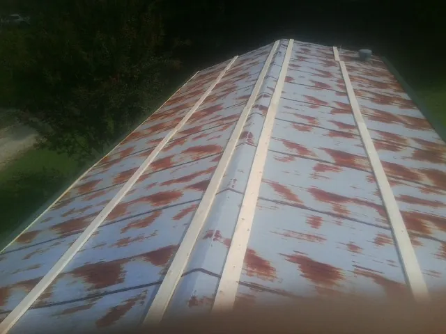 Rusted metal roof panels with new wood purlins before replacement in Bellmawr