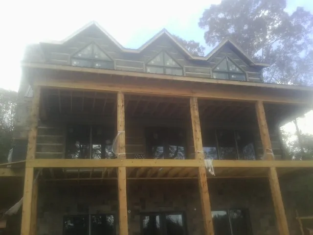 Dormers and porch framing on a large log home under construction — Roof Coating work by our crew in Bellmawr