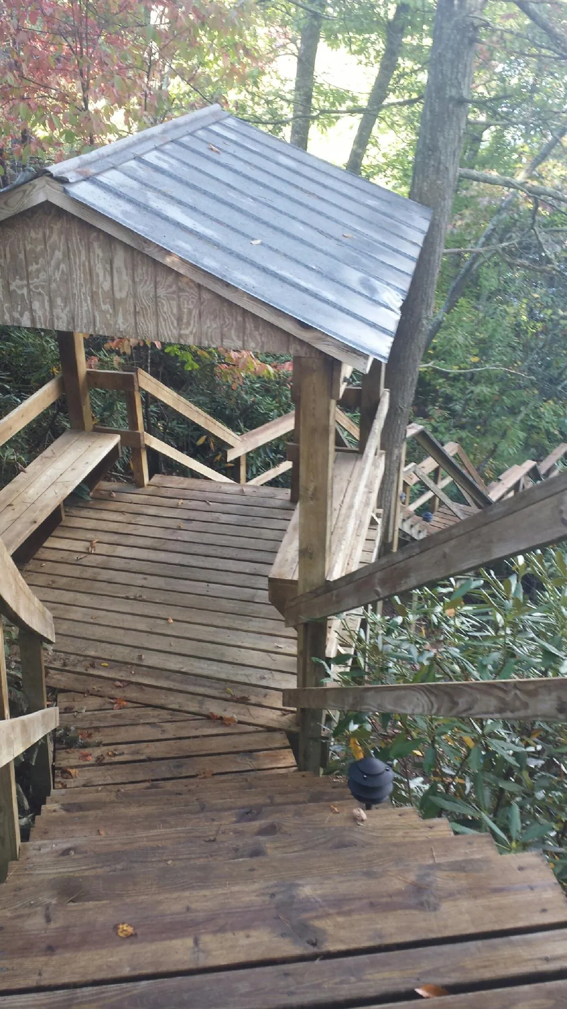 Metal roofed shelter over wooden steps on a wooded walkway — Skylight Repair & Installation work by our crew in Bellmawr
